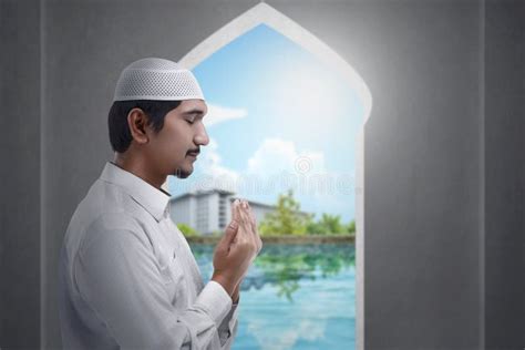 Asian Muslim Man Standing While Raised Hands And Praying Stock Image