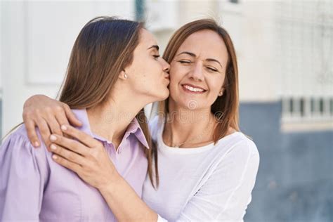 Two Women Mother And Daughter Hugging Each Other And Kissing At Street
