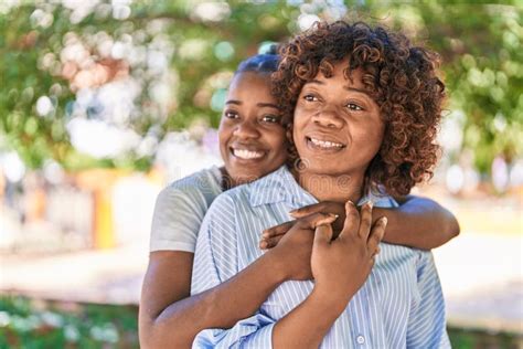 african american women mother and daughter hugging each other at park stock image image of