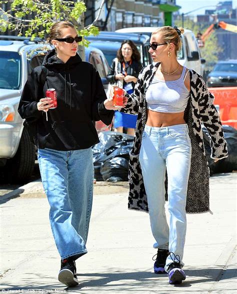hailey baldwin flashes taut midriff as bff bella hadid keeps covered in baggy ensemble out in