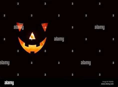 Halloween Pumpkin With Scary Glowing Face On Black Background Isolated