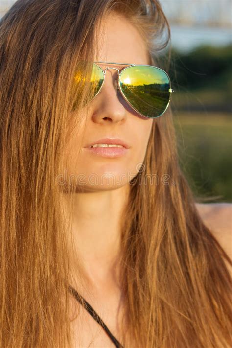 Beautiful Girl With Long Hair With Tanned Skin Wearing Sunglasses On