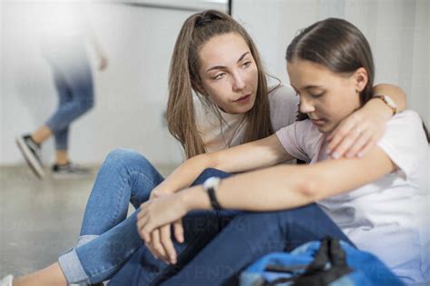 Teenage Girl Consoling Sad Friend In School Stock Photo