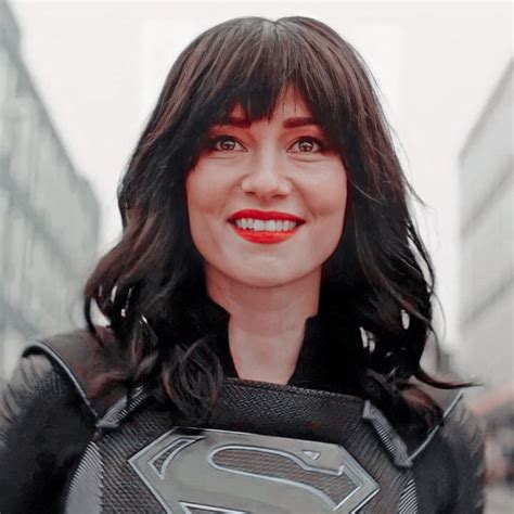 A Woman In A Superman Costume Is Smiling For The Camera