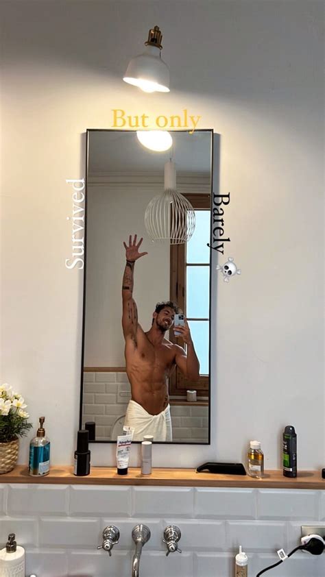 A Man Taking A Selfie In Front Of A Bathroom Mirror With His Hand Up