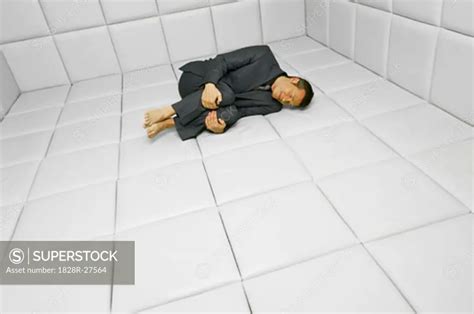 Man In Fetal Position In Padded Room SuperStock