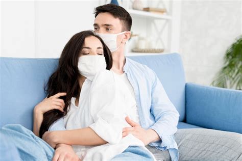 Free Photo Couple With Face Masks Embraced On Sofa
