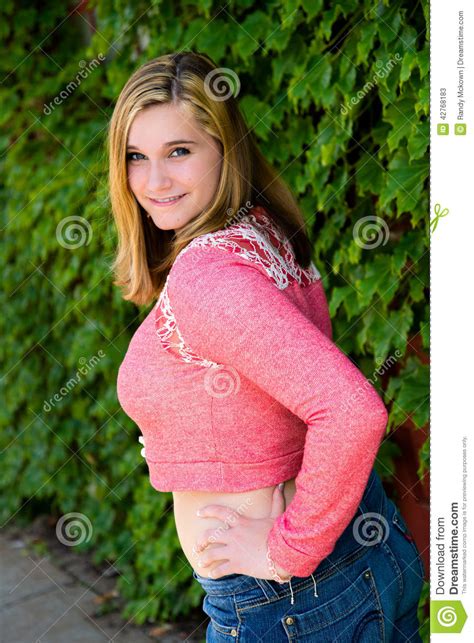 Many teen girls prefer leaving their hair as is rather than wasting so much time on styling. Pretty Teen Girl Pink Sweater & Green Ivy Stock Photo ...