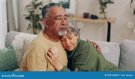 Senior Couple Love And Hug For Empathy And Comfort Or Security On Home Sofa Elderly Man And