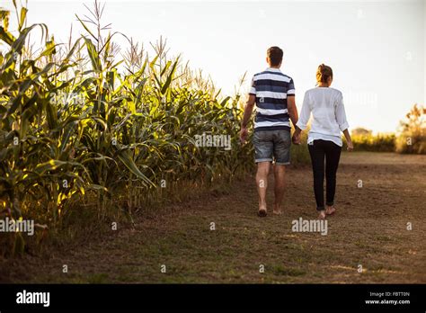 Couple Walking Along Dirt Road Next To Cornfield Stock Photo Alamy