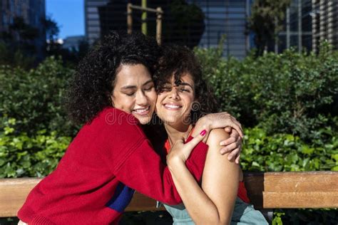 Smiling Lesbian Couple Embracing And Relaxing On A Park Bench Stock Image Image Of