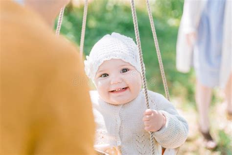 Stylish Young Parents Swings Their Happy One Year Old Daughter Stock