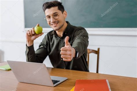 That is not to suggest that male teachers have to become a father figure, but they certainly can show young people what a responsible, caring and fun man looks like. Smiling Male Teacher Glasses Holding Apple Showing Thumb ...