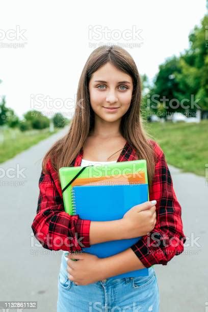girl schoolgirl teenager 1015 years old summer city after school lessons in hands documents and