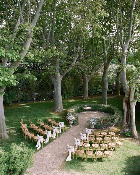 An Outdoor Ceremony Set Up In The Middle Of A Park With Lots Of Chairs