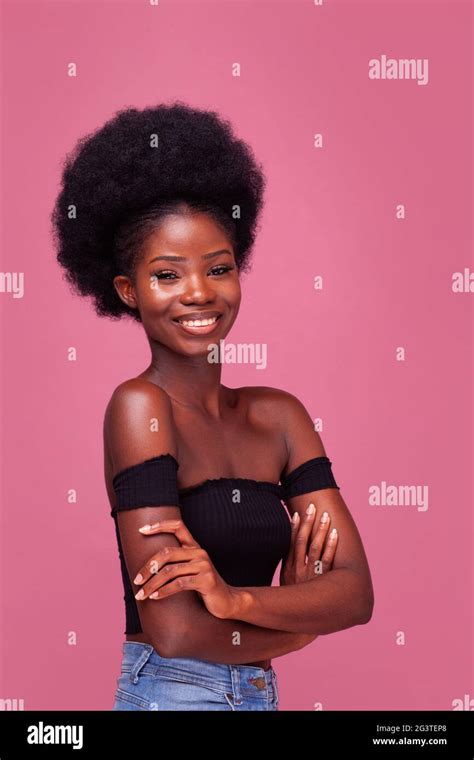 beautiful african american girl with gorgeous afro hairstyle standing smiling with arms folded