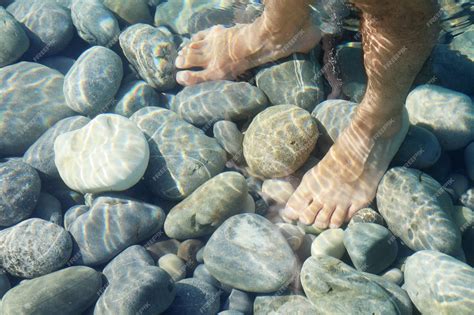 Premium Photo Male Bare Feet In Water On Underwater Stones In Soft