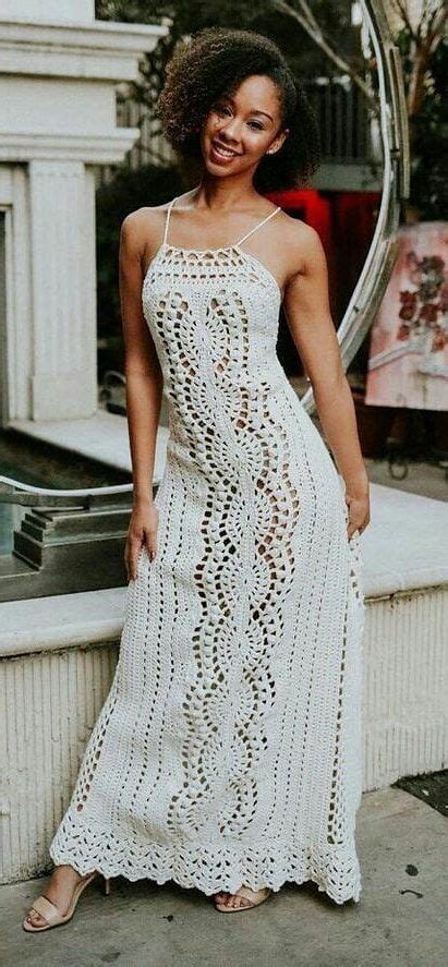 A Woman In A White Crochet Dress Posing For The Camera With Her Hand On