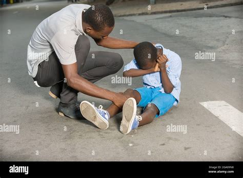 Father Comforting His Son Crying Child Fallen On The Road Having A