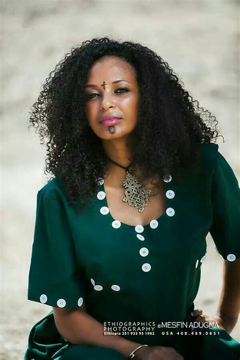 A Woman Sitting On The Ground Wearing A Green Dress With White Polka