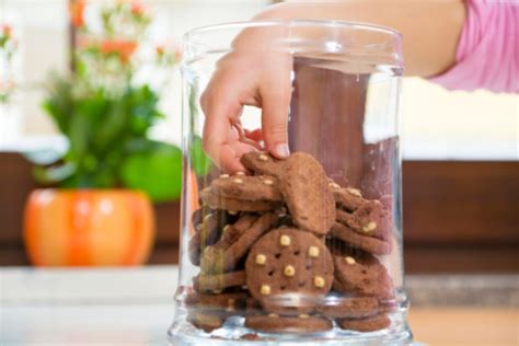 Childrens Hand In The Cookie Jar Grabbing A Cookie Stock Photo