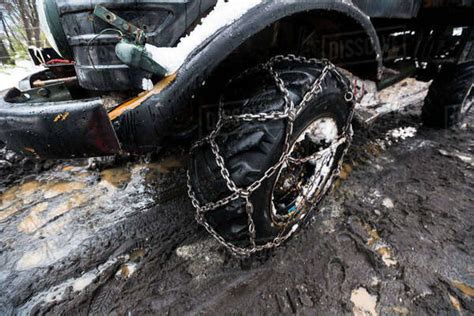 Heavy Duty Truck With Chained Tires Driving Through Mud And Snow