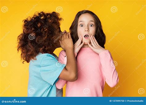 Girl Telling Secret To Her Friend Whispering In Ear Stock Photo