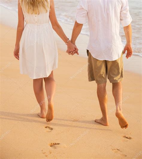 Pareja Romántica Cogida De La Mano Caminando Por La Playa Al Atardecer