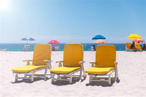 Three Yellow Beach Chairs On A Sunny Day On Camps Bay Sandy Beach Stock