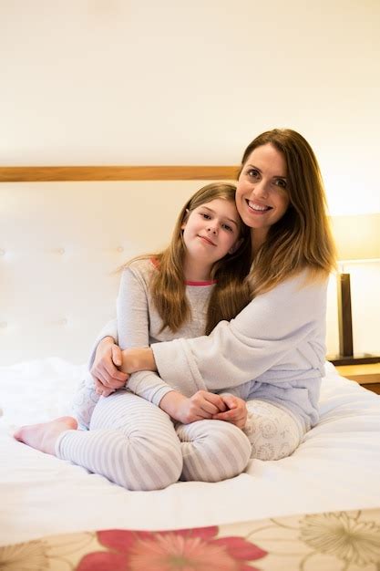 Free Photo Mother Embracing Daughter In Bedroom