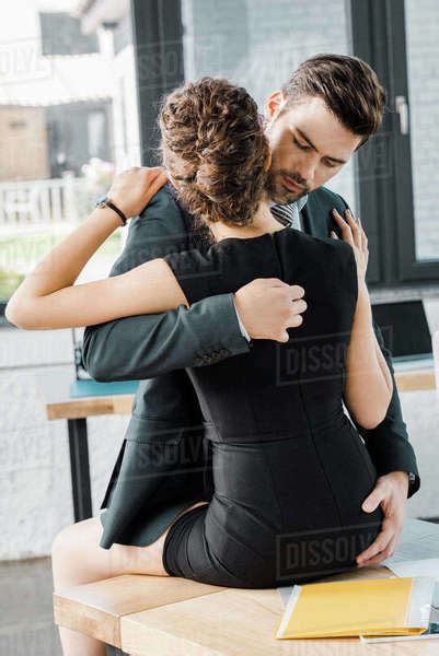 Passionate Businessman Unzipping Dress Of Seductive Businesswoman At