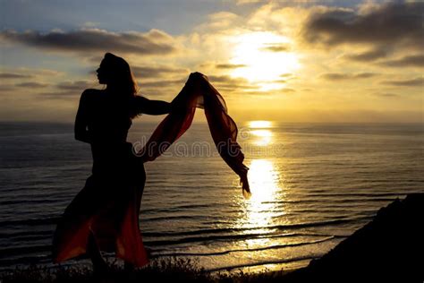 Lovely Brunette Bikini Model Relaxing On The Shoreline At Sunset Stock