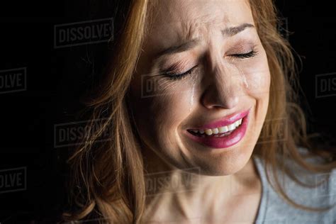 Close Up Portrait Of Young Beautiful Woman Crying Isolated On Black