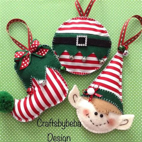 Three Christmas Ornaments Are Sitting On A Green Tablecloth With Red