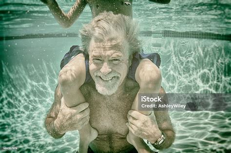 Grandpa Plays With His Grandson Underwater In A Pool In Summer Stock