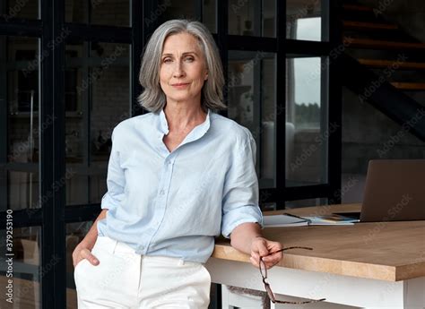 Confident Stylish European Mature Middle Aged Woman Standing At Workplace Stylish Older Senior