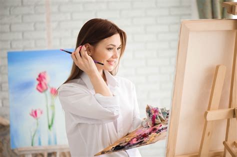 Premium Photo Woman Paints Picture On Canvas With Oil Paints In Her