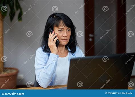 Mulher Idosa Falando Ao Telefone Em Seu Local De Trabalho Com Laptop