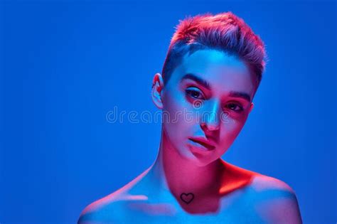 Young Beautiful Girl With Blonde Short Hair Posing Against Blue Studio