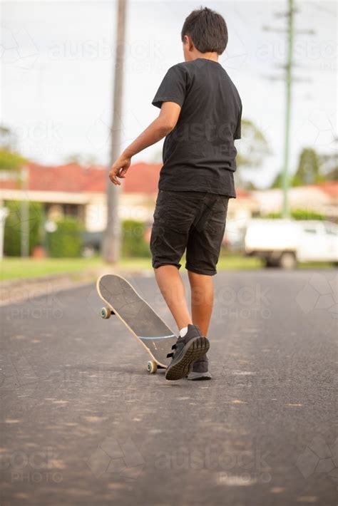 Image Of Young Aboriginal Boy Riding A Skateboard Austockphoto