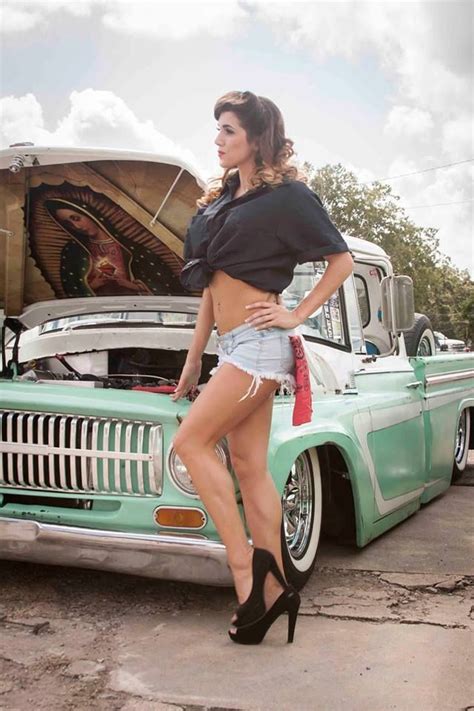 a woman in high heels standing next to an old car