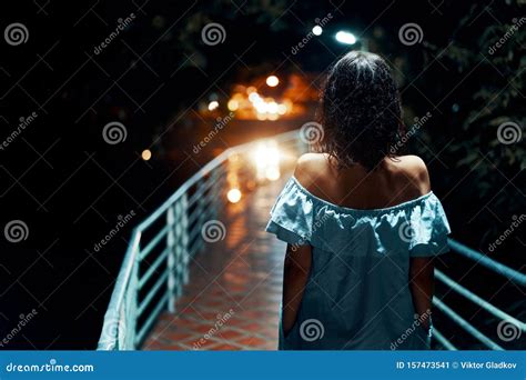 Young Lonely Tourist Cutie Girl Sitting On Stone On Shore Of River In