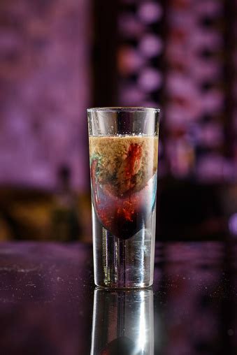 Once the shot is almost full, a small amount of blue curacao is added, and once that settles, a small splash of grenadine tops the drink off. Alien Brain Hemorrhage Cocktail Stock Photo - Download ...
