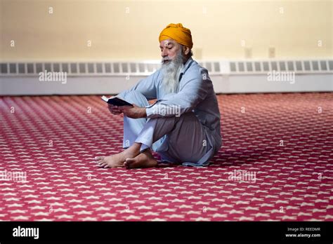 A Devout Sikh Man Reading His Prayer Book At A Temple In Richmond Hill