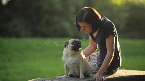 Young Asian Beautiful Woman Blowing A Kiss To Her Pug Dog At The Sofa