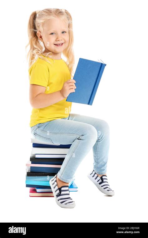 Cute Little Girl Sitting On Stack Of Books Against White Background