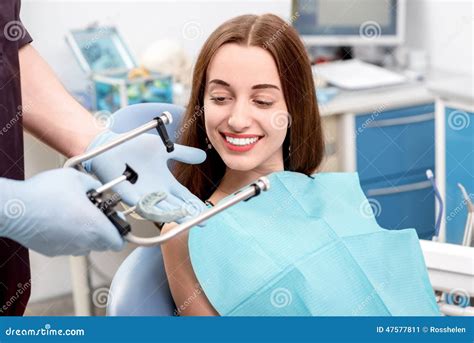 Dentista Que Visita Paciente De La Mujer Joven En El Dental Imagen De