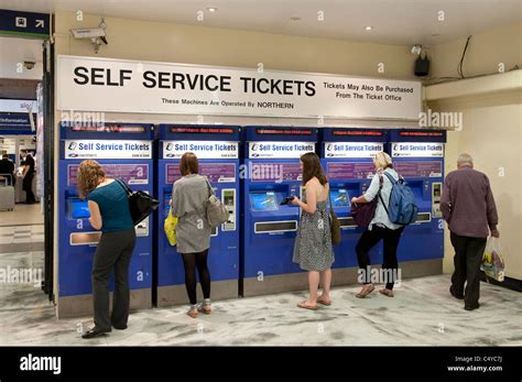 Passengers Buying Tickets From Automated Ticket Machines At Leeds