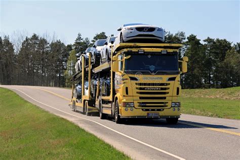 Yellow Scania Car Carrier Transports New Cars On Spring Road Editorial