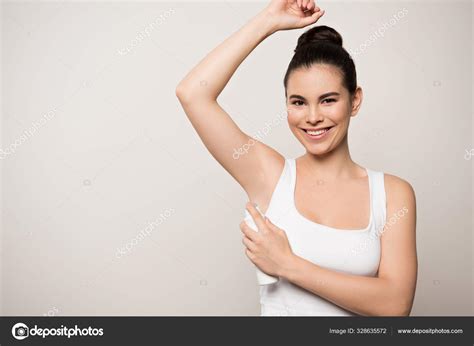 Cheerful Woman Smiling Camera While Applying Deodorant Underarm Isolated Grey Stock Photo
